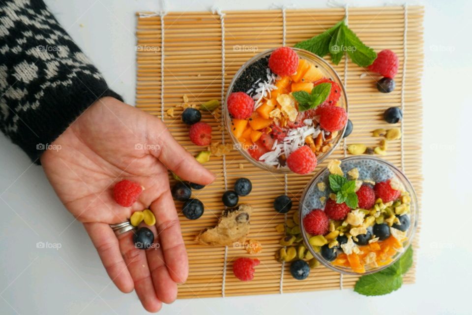 Healthy Fresh Fruit Smoothie Bowl - creamy raspberry smoothie topped with peach, seeds, dry coconuts,  nuts, blueberry and strawberry