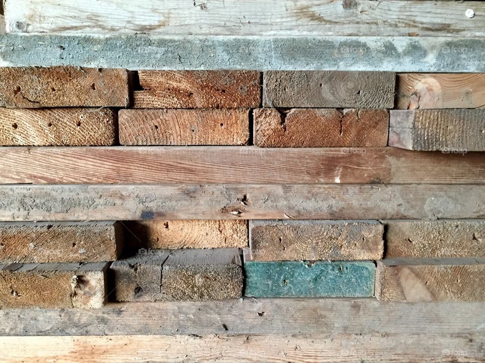 Ends and side-view of stacked used and unused lumber 