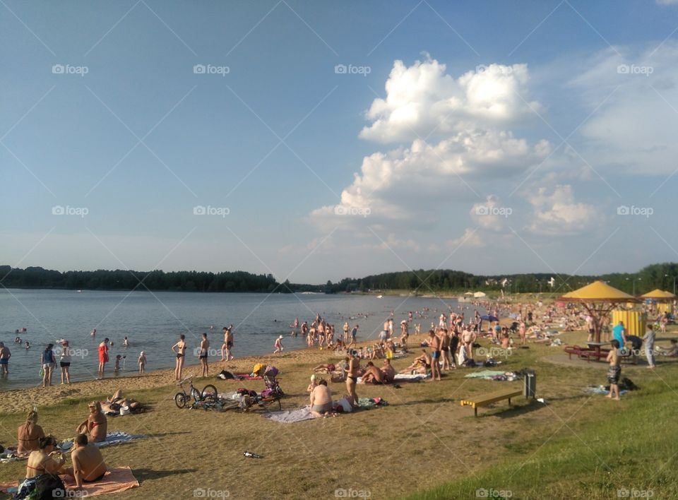 people resting on a lake shore summer heat