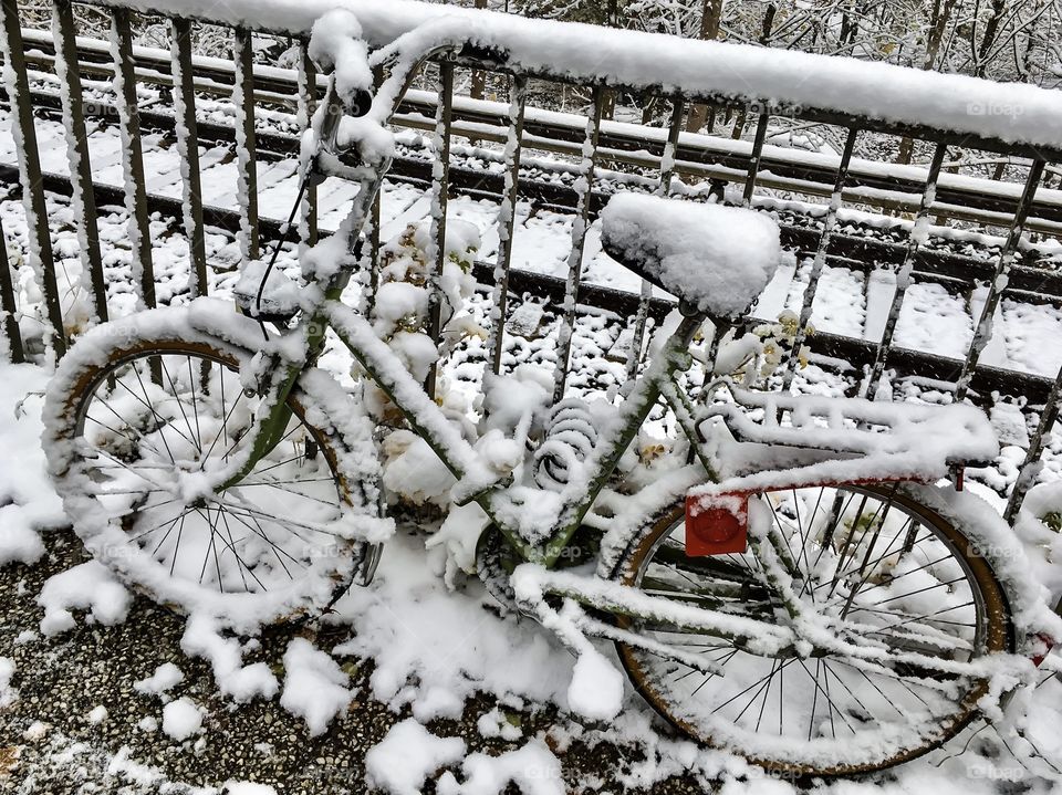 Lonely bicycle covered by snow