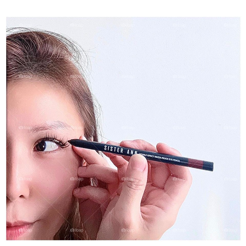 Asian woman with Korean brand of Eyeliner of different tones and glide well