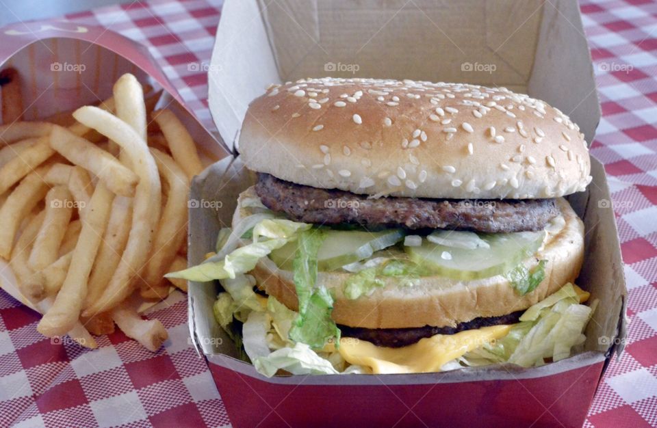 McDonald’s big Mac and a large fry on a red and white checkerboard back ground