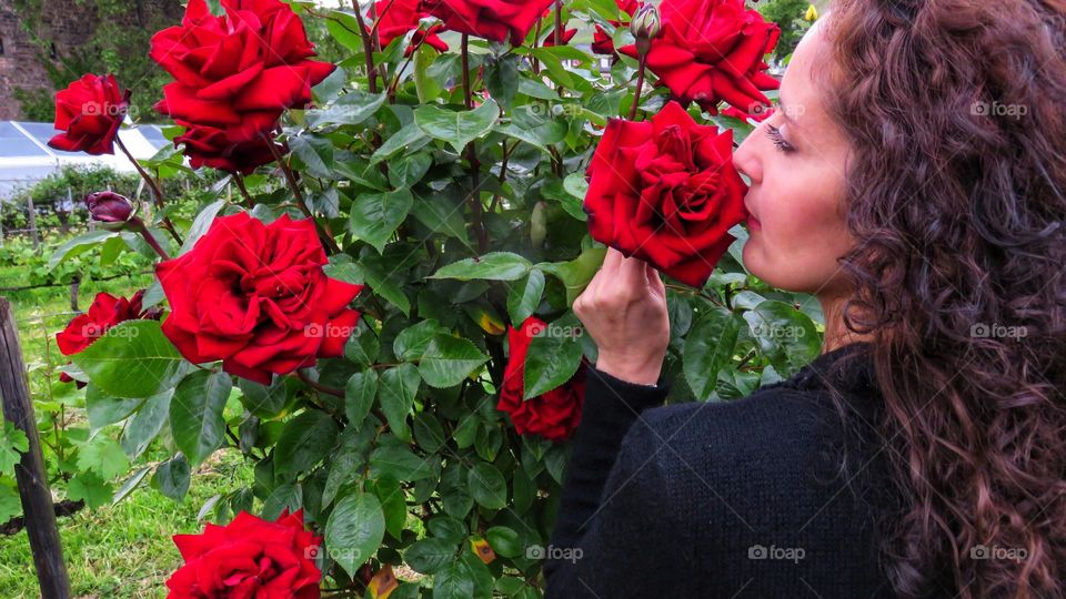 woman in profile smells wonderful red roses