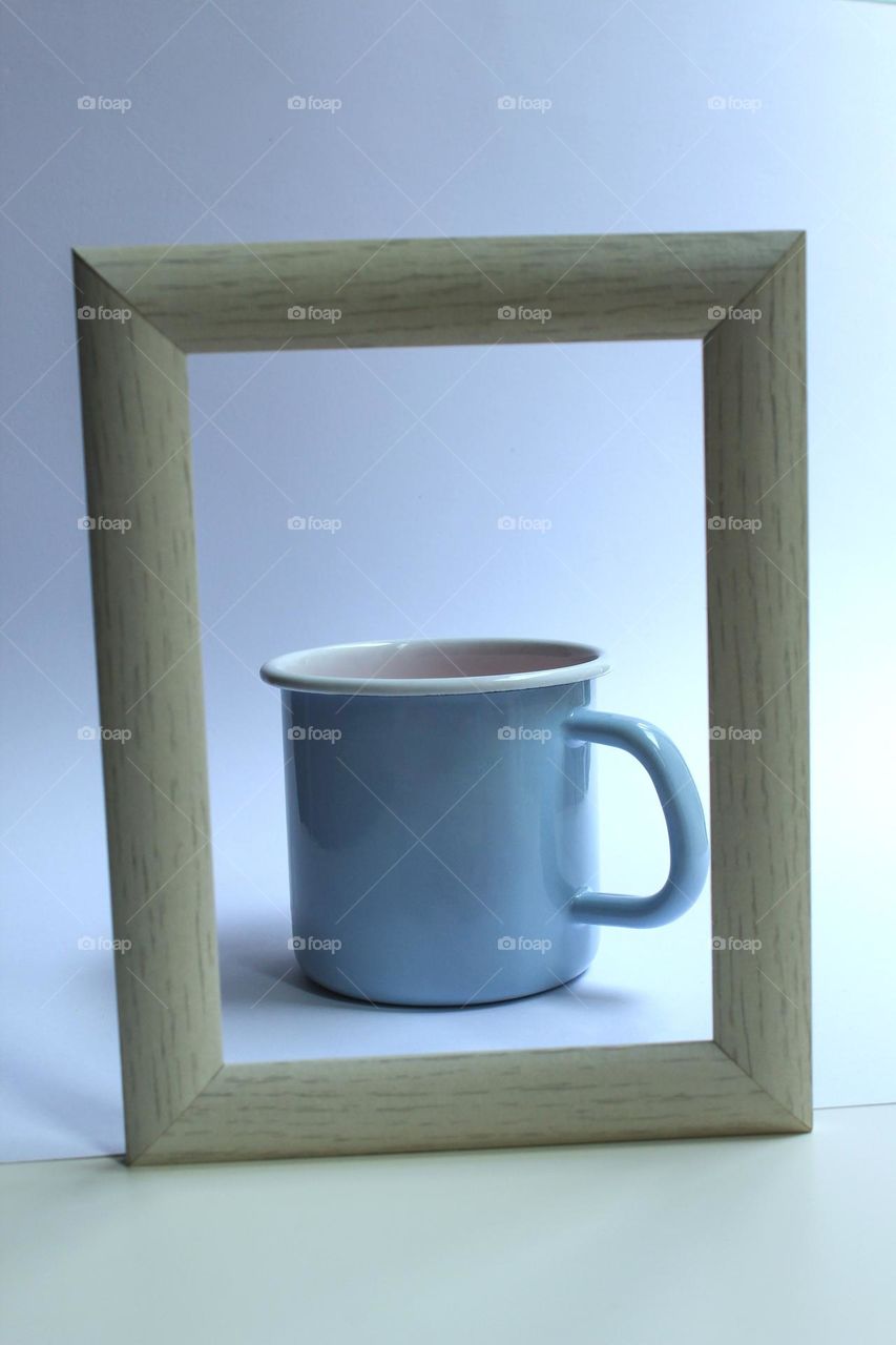 Antique baby blue milk pots with a wooden retro frame on a white background