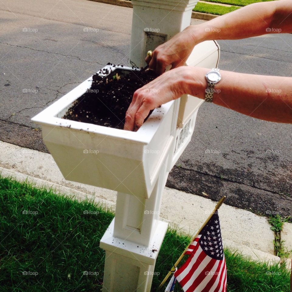 Woman planting in a mailbox planter
