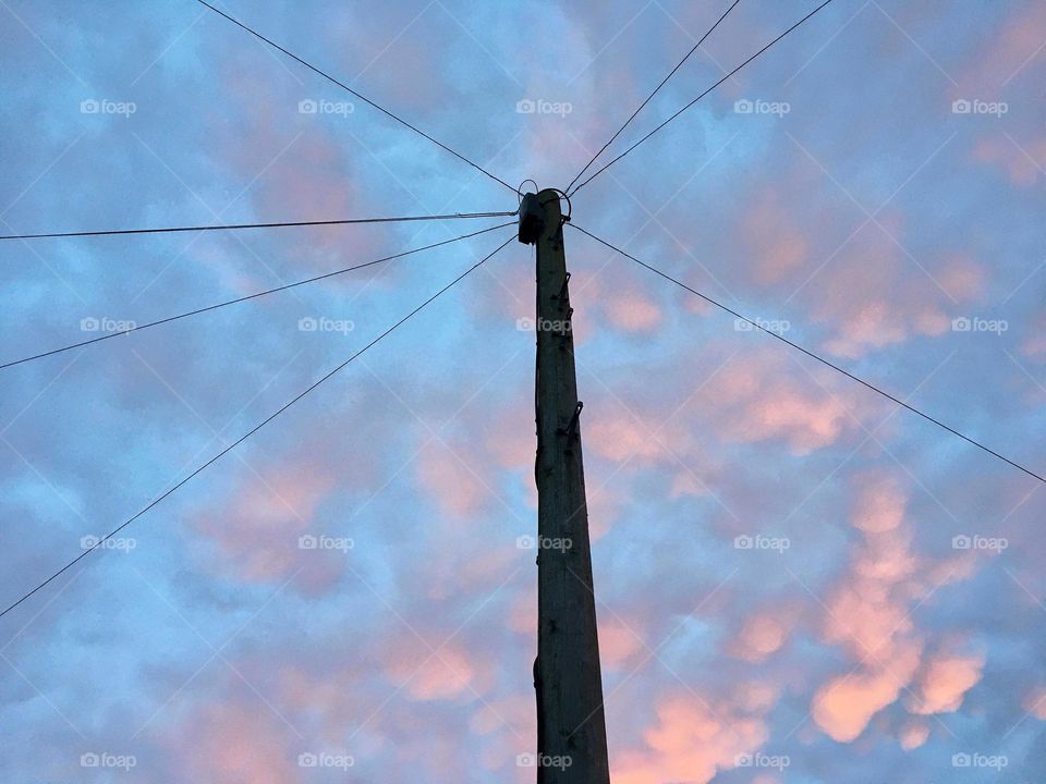 Triangle shapes spotted high above my head formed by wires attached to a telegraph pole 