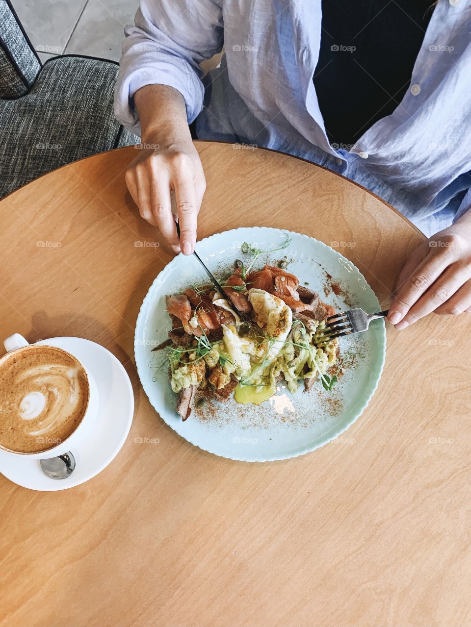 Young woman eating healthy food in cafe, top view 