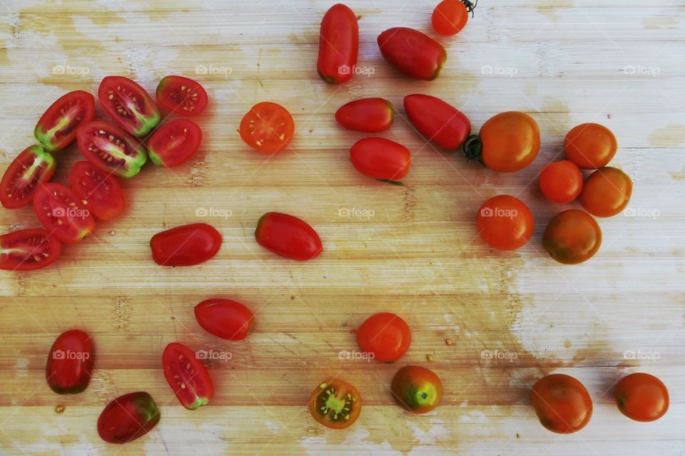 Small tomatos. Whole and half Small tomatos in the counter