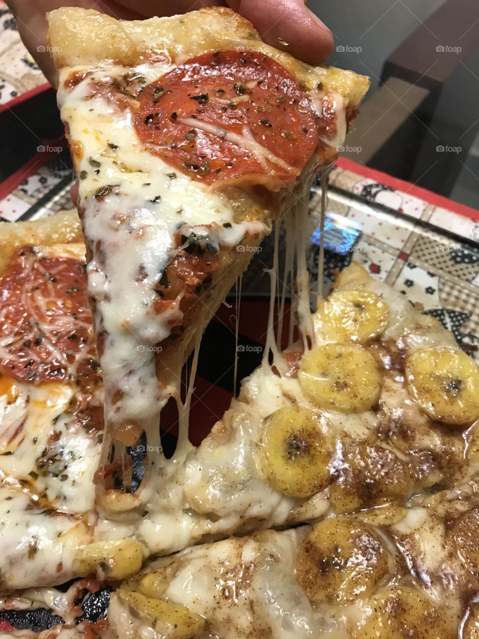 A slice of pepperoni pizza being served while the cheese melts