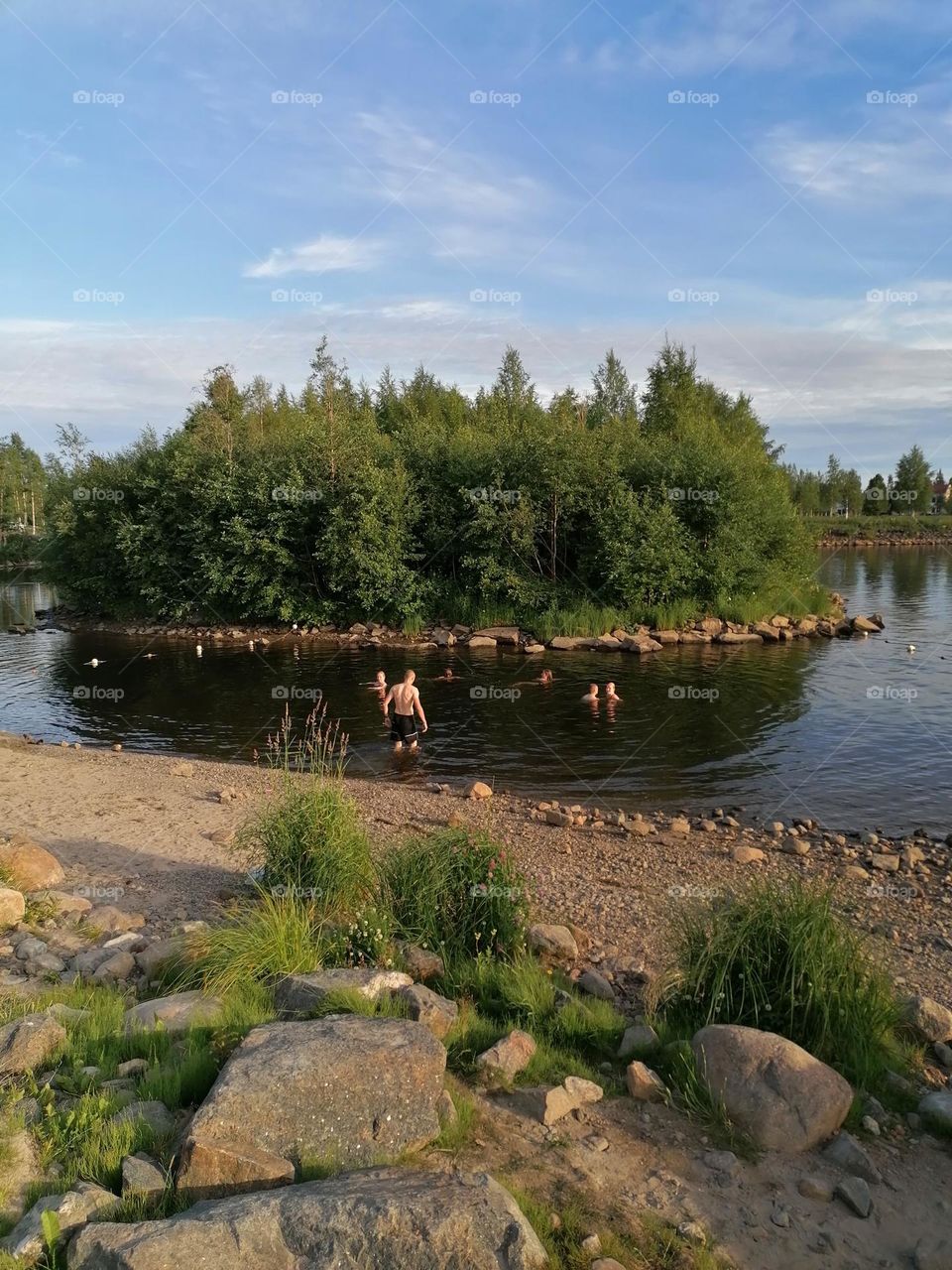 People swimming in Tornio river, on the shores of Finnish Lapland