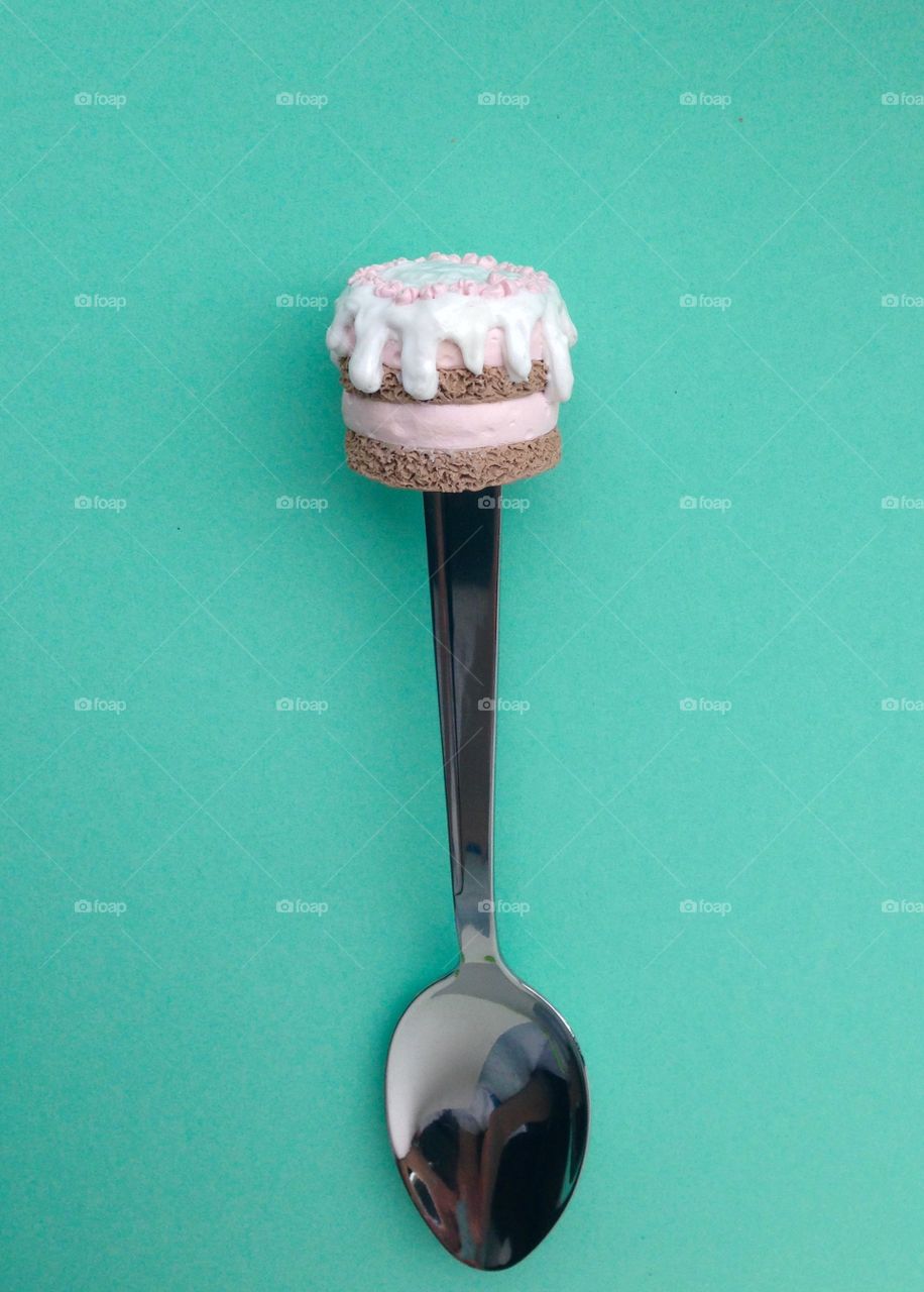 Spoon with cupcake on top isolated on green background 