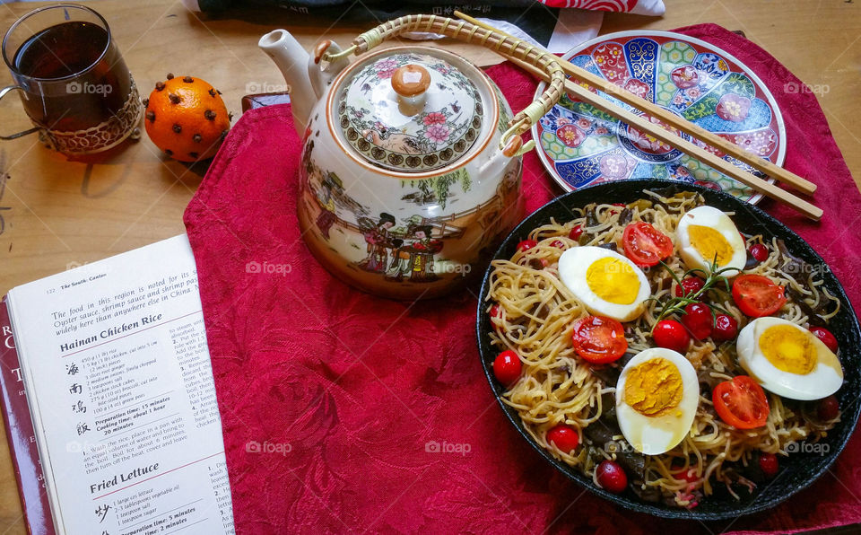 Oriental style lunch with tea and a cooking book