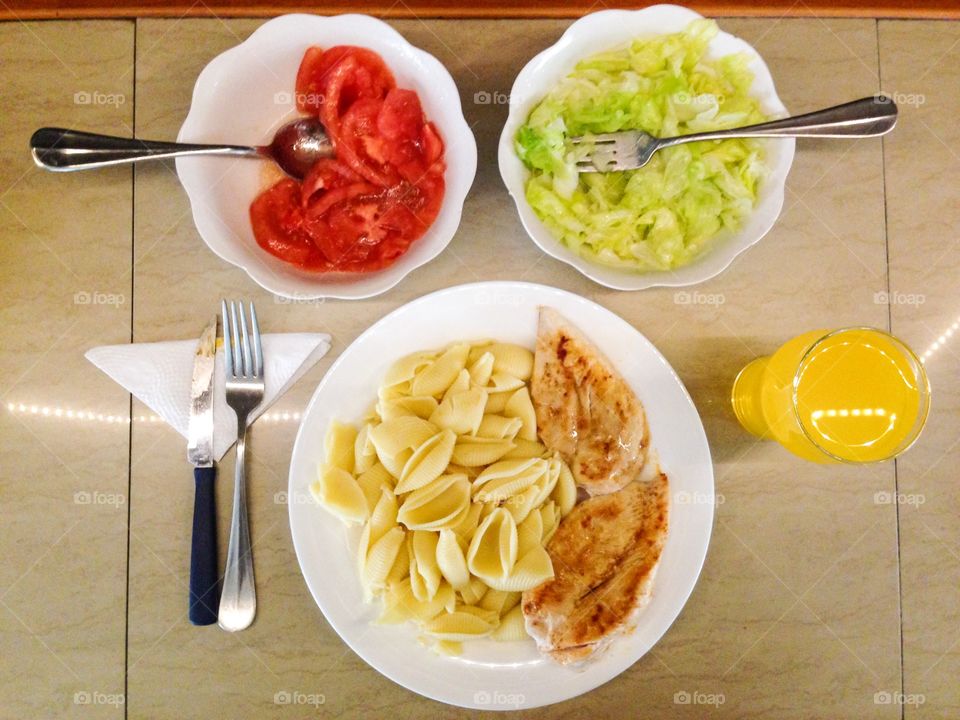 Chicken and pasta with some salads and juice
