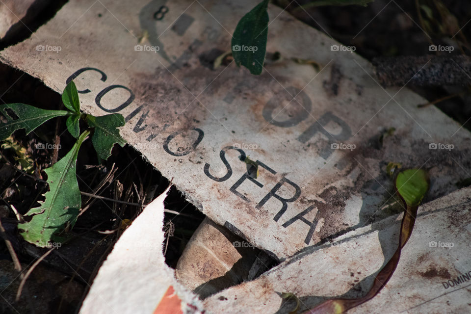 Jornal rasgado e abandonado com mensagem profunda.