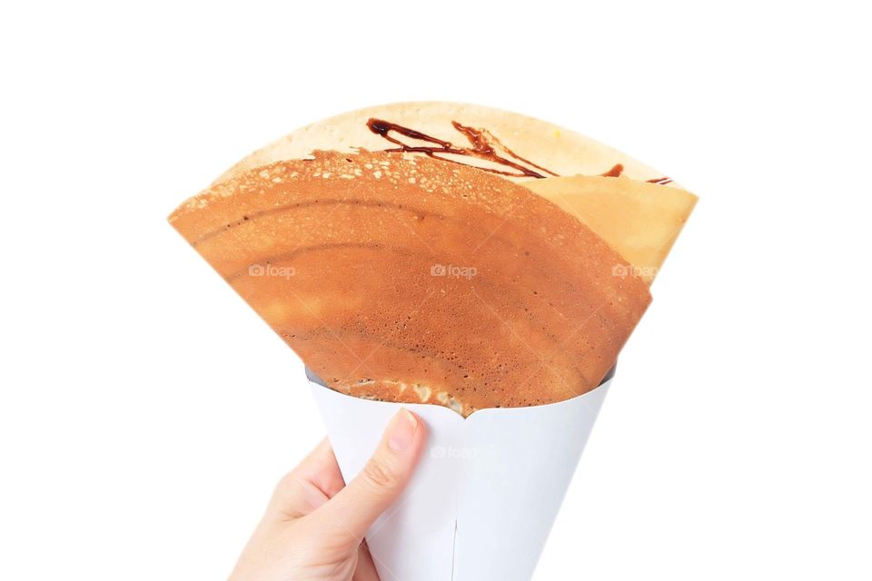 Dessert Chocolate Sauce with Dried Shredded Pork Crepes Pancake,Top View. Woman is Hand Holding Brown Crepe Homemade on White Background Great For Any Use.