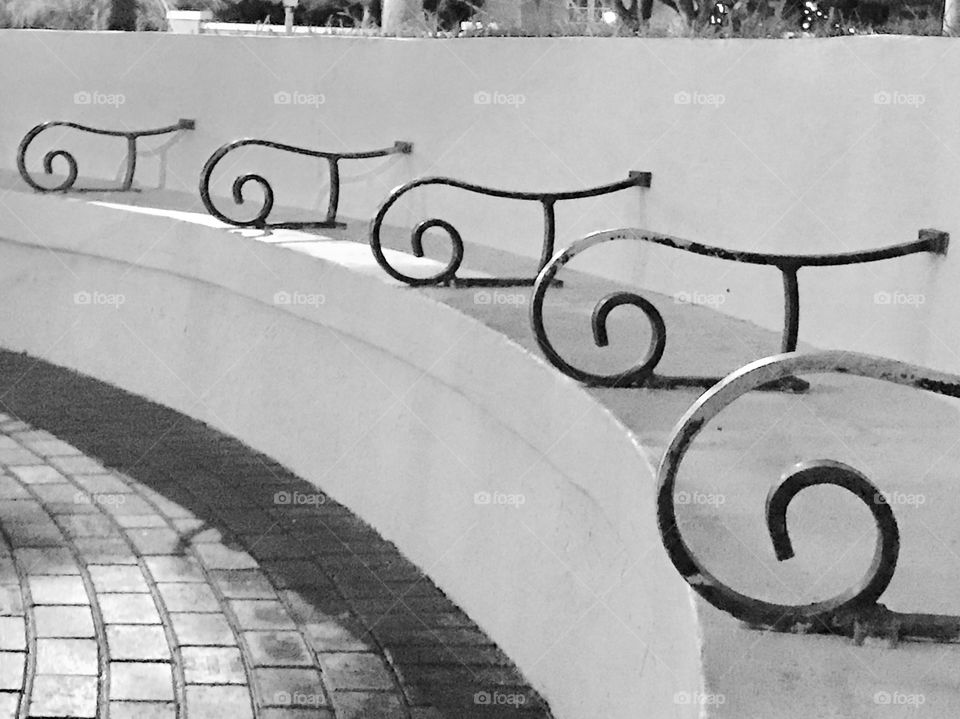 Curved bench with decorative symmetrical iron work