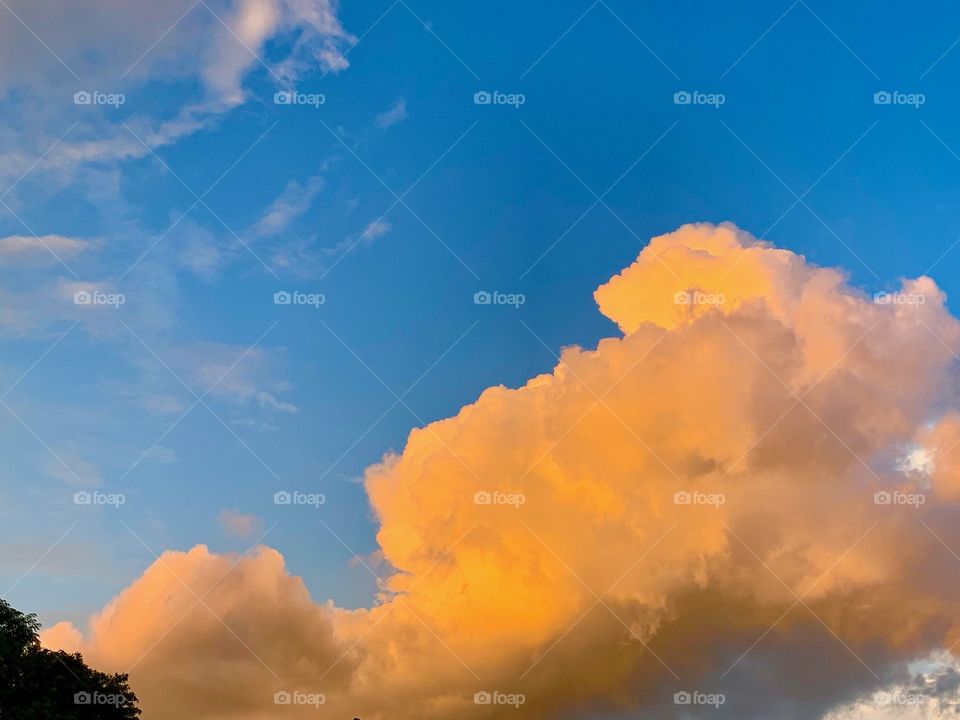large cloud with the setting sun against blue sky