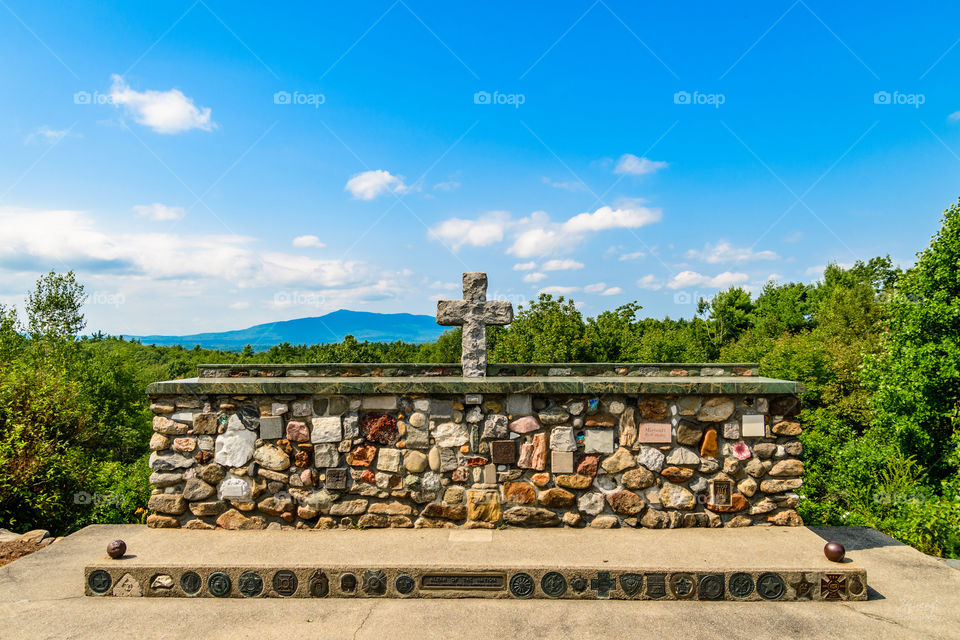 Amazing stone cross with a mountain view of the background. 
