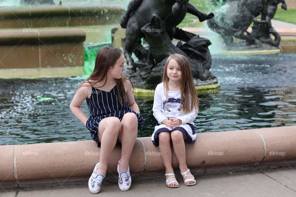 sisters by a fountain