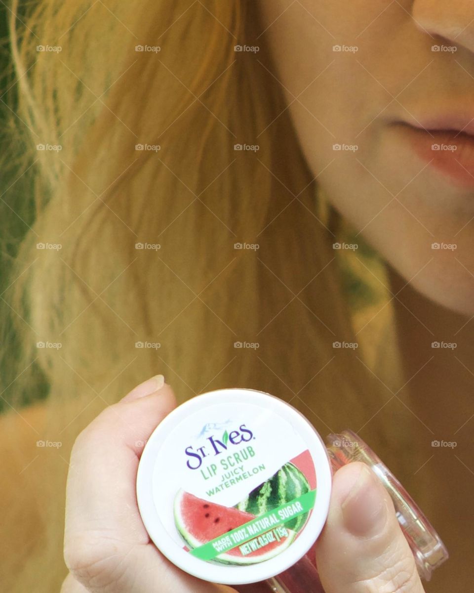 Woman with a smile holding her favorite lip scrub