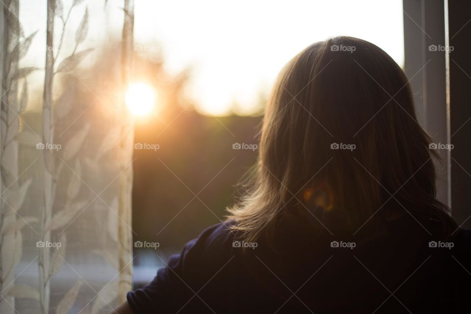 Rear view of woman looking out window