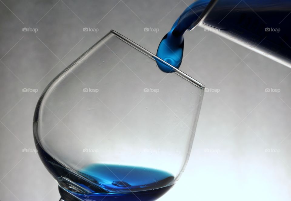 Blue cocktail pouring in drinking glass