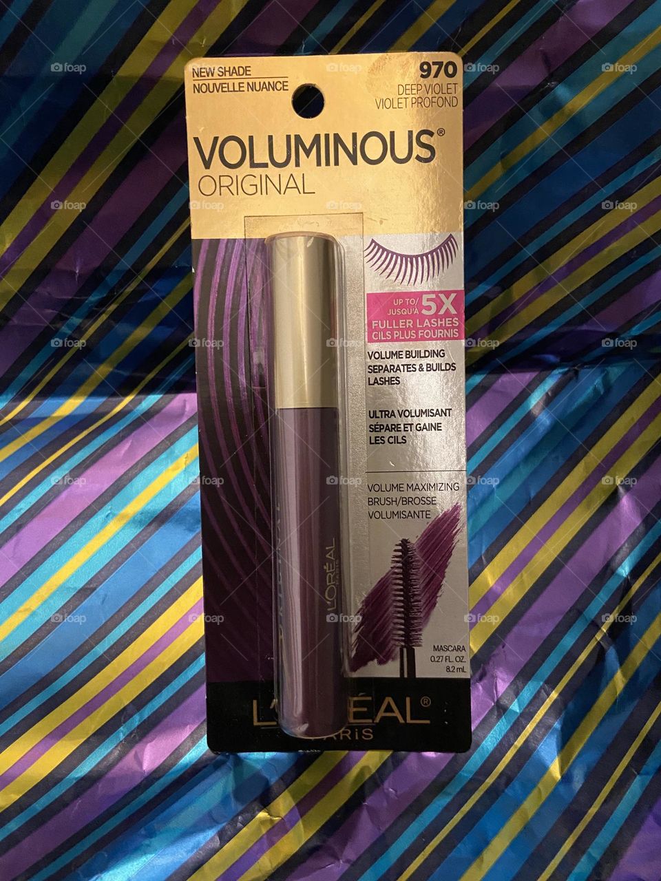 A photo of L’Oréal Voluminous Mascara in the fun shade of Deep Violet against a rich striped background in complimentary colors. Purple to me is sophisticated yet playful, rich and beautiful.
