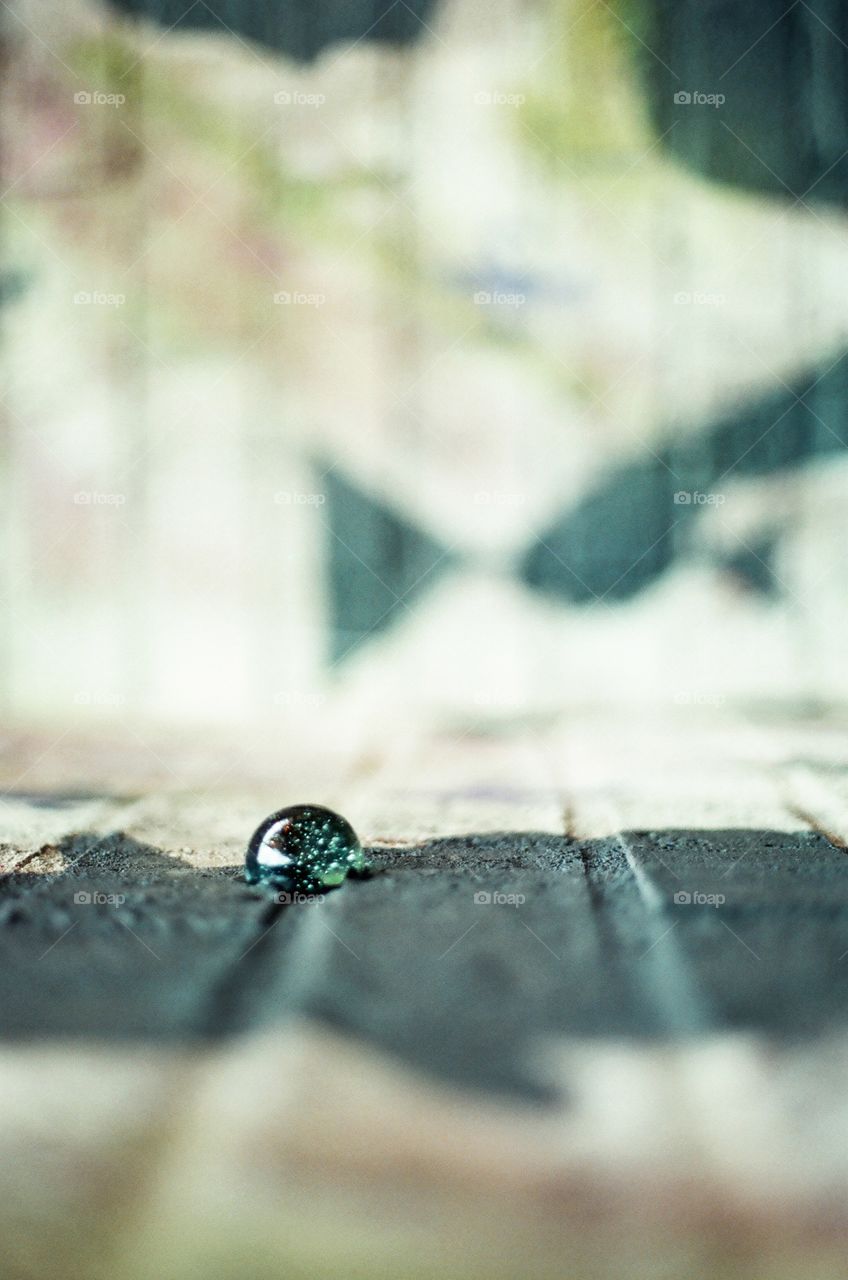 Glass marble isolated in concrete taken in Nashville, TN in Printer's Alley on 35 mm film. 