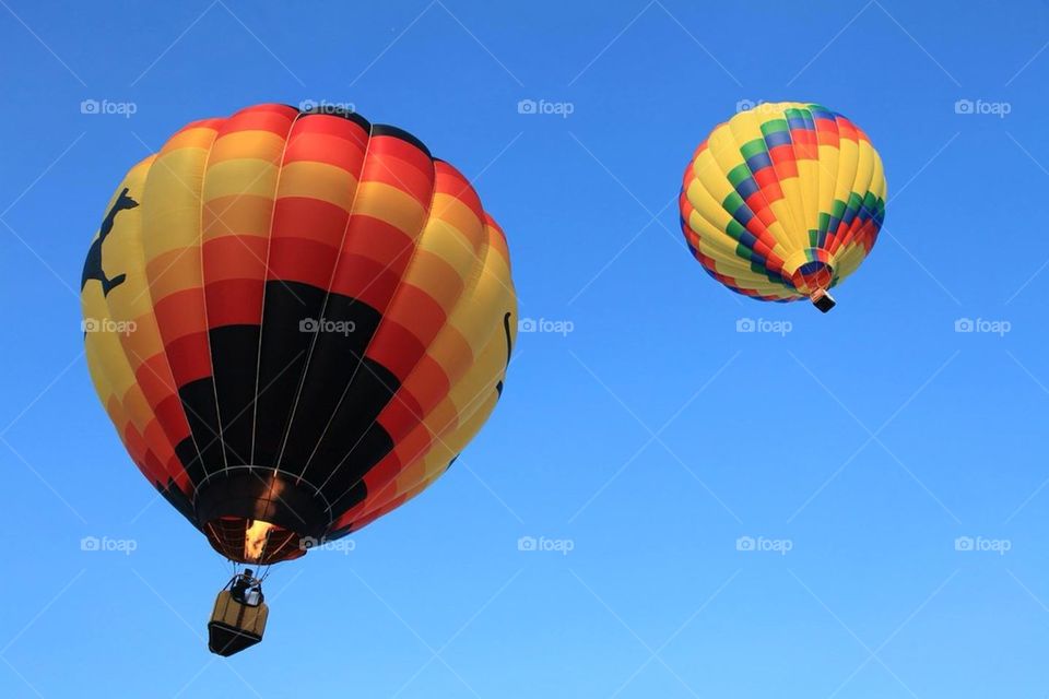 Two floating hot air balloons overhead