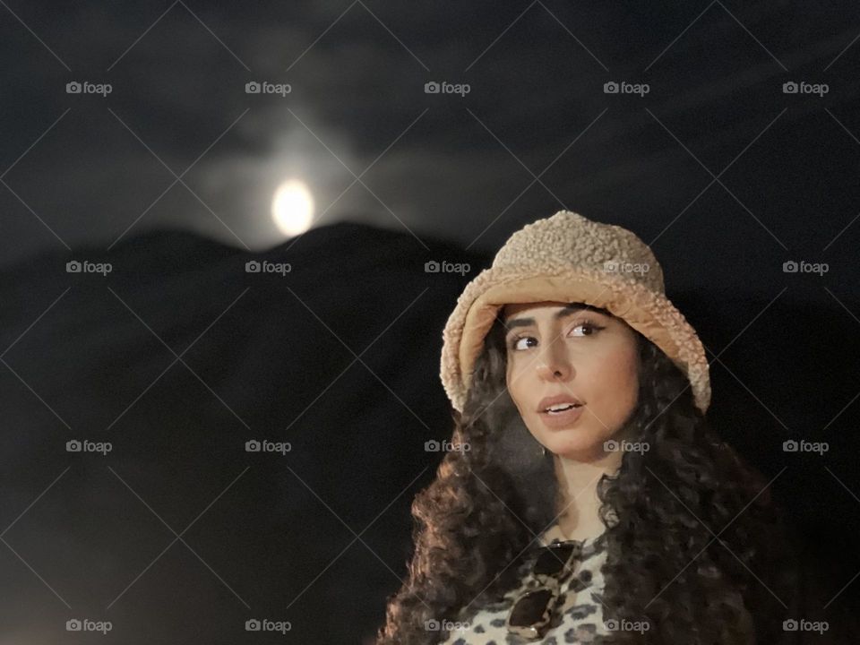A girl with curly hair and a bright moon