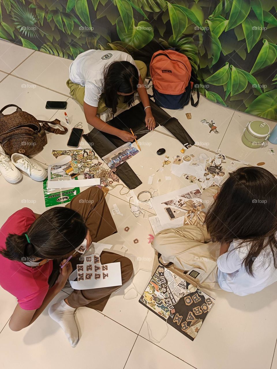 "Amid scattered clippings and laughter, creativity unfolds, stitching memories together."