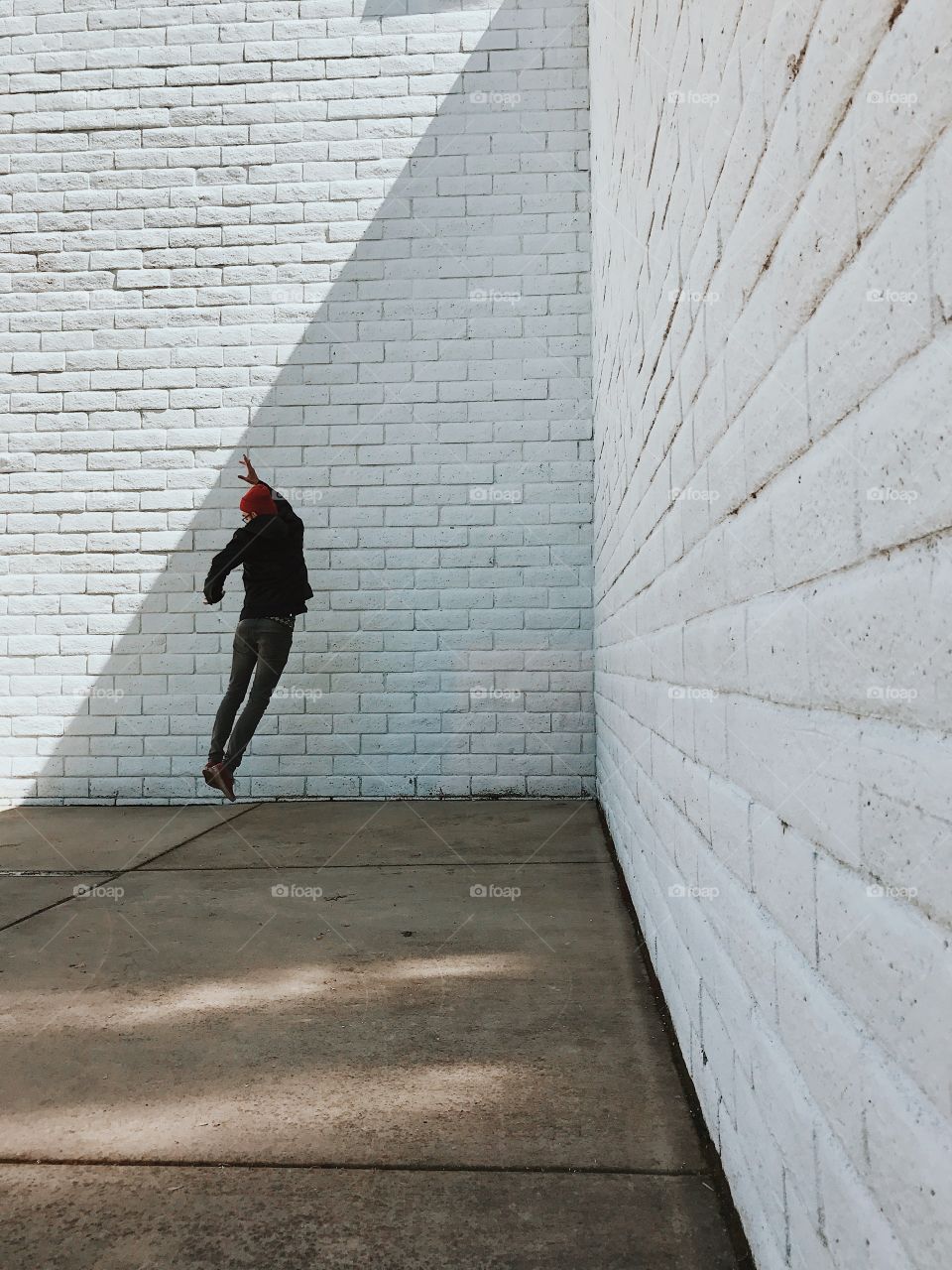 Jumping near a white wall, with a slant of light. 