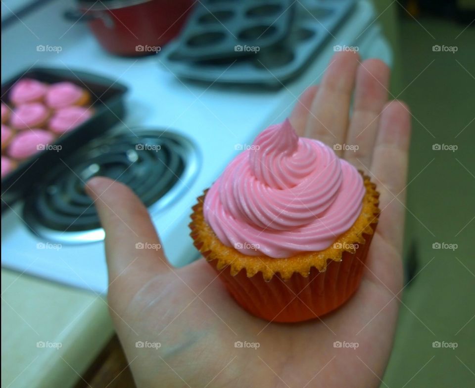 Pink Cupcake. Showing off a finished cupcake to a friend