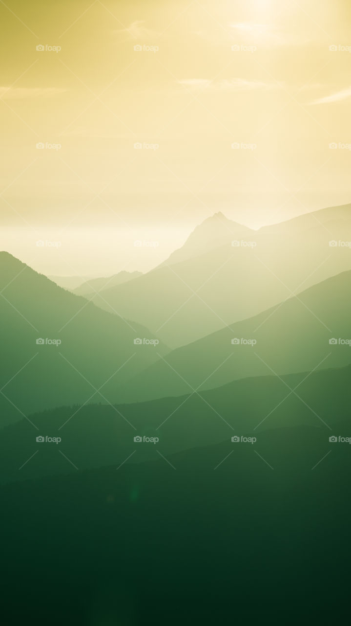 An inspiring mountain landscape. Tatry mountains in Slovakia. A beautiful wallpaper for smartphone screen. Warm summer haze, abstract gradient with perspective.