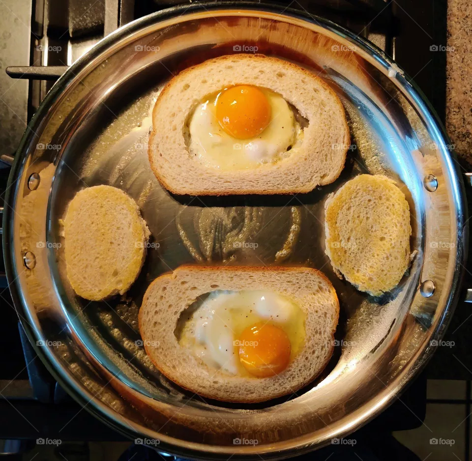 Eggs in the hole frying on the stovetop