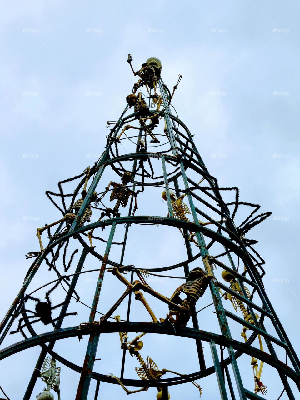 Skeletons climbing a conical cage