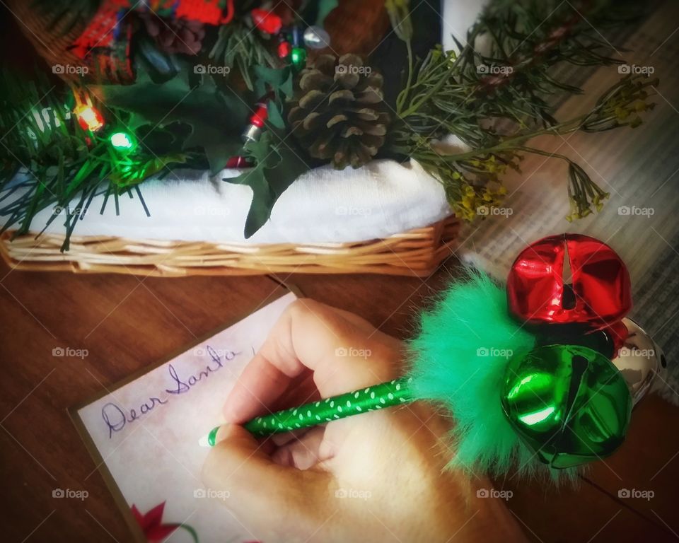 Writing a letter to Santa with a jungle bell pen