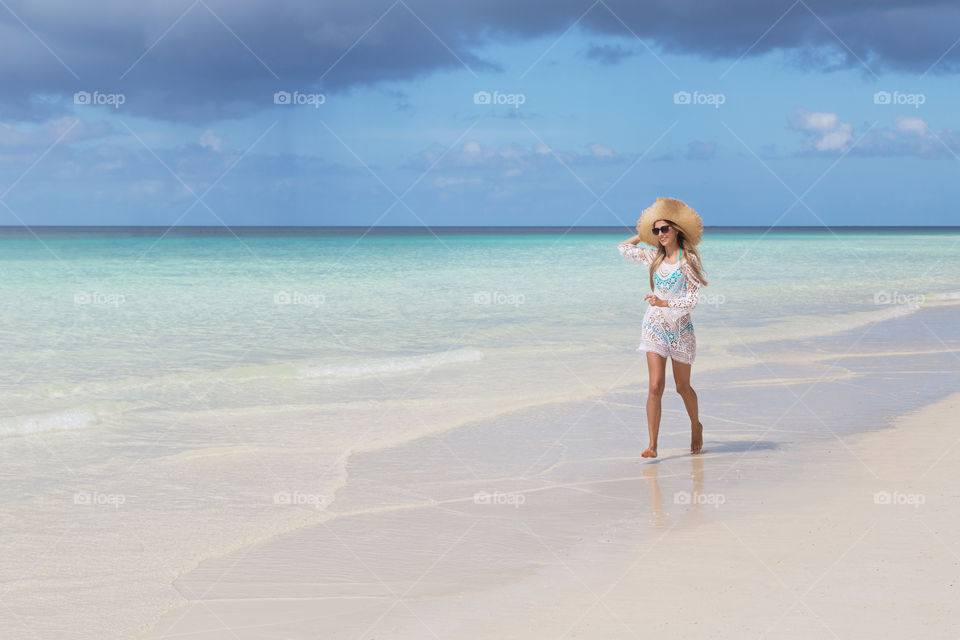 Happy woman running on the beach 