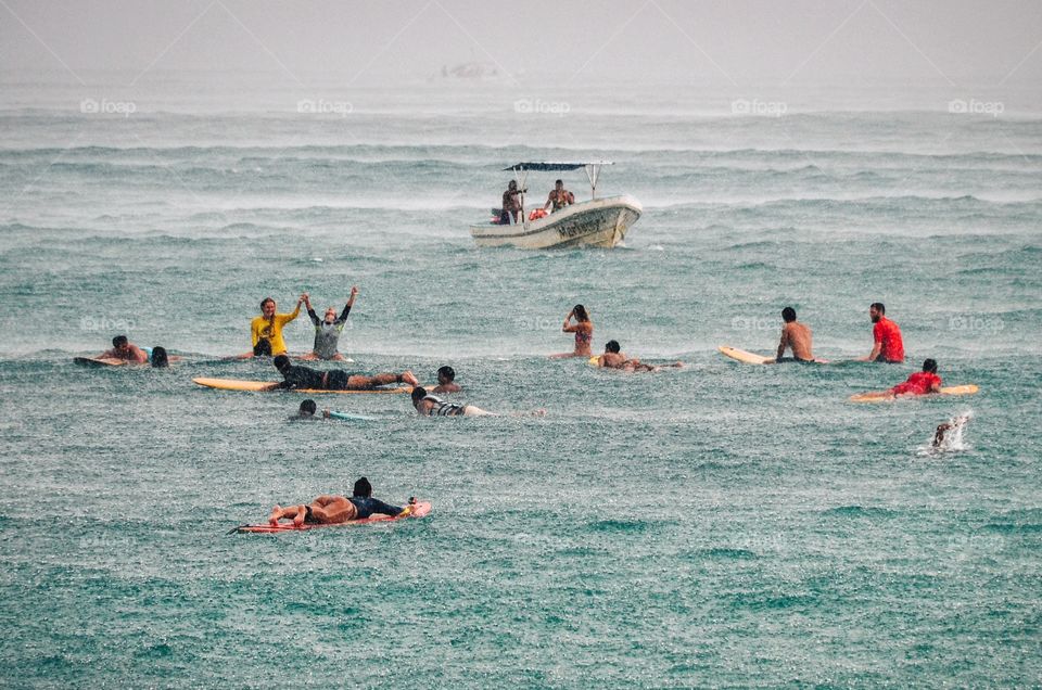A group of surfers enjoying a short and warm rain while waiting for waves