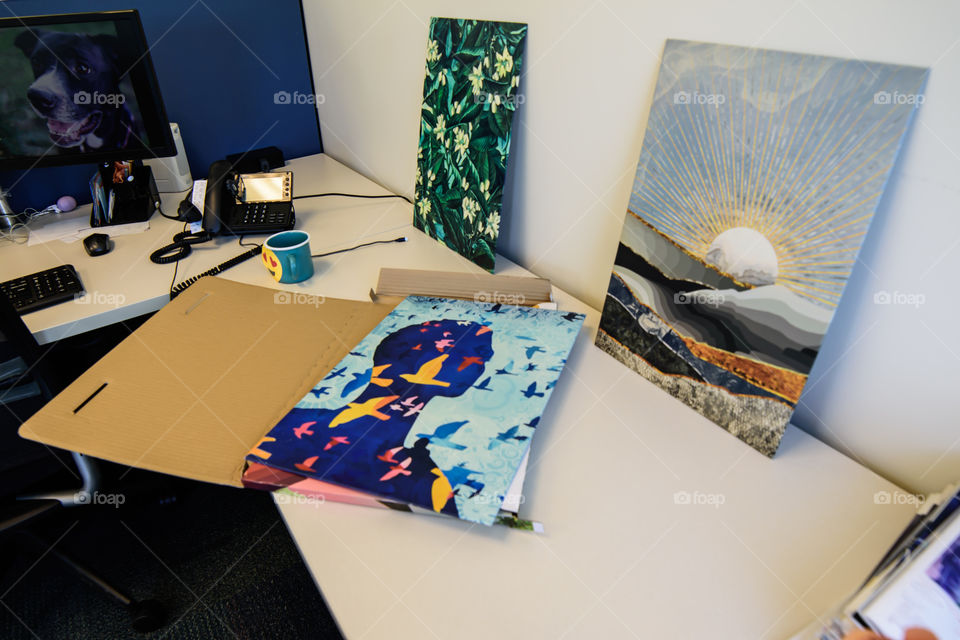 Inspiring office art decor from Displate on desk with computer screen and Displate in open box ready to put up 