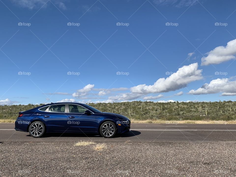 2020 Hyundai Sonata parked along the highway in the high desert of Arizona, with a beautiful sky with clouds in the background