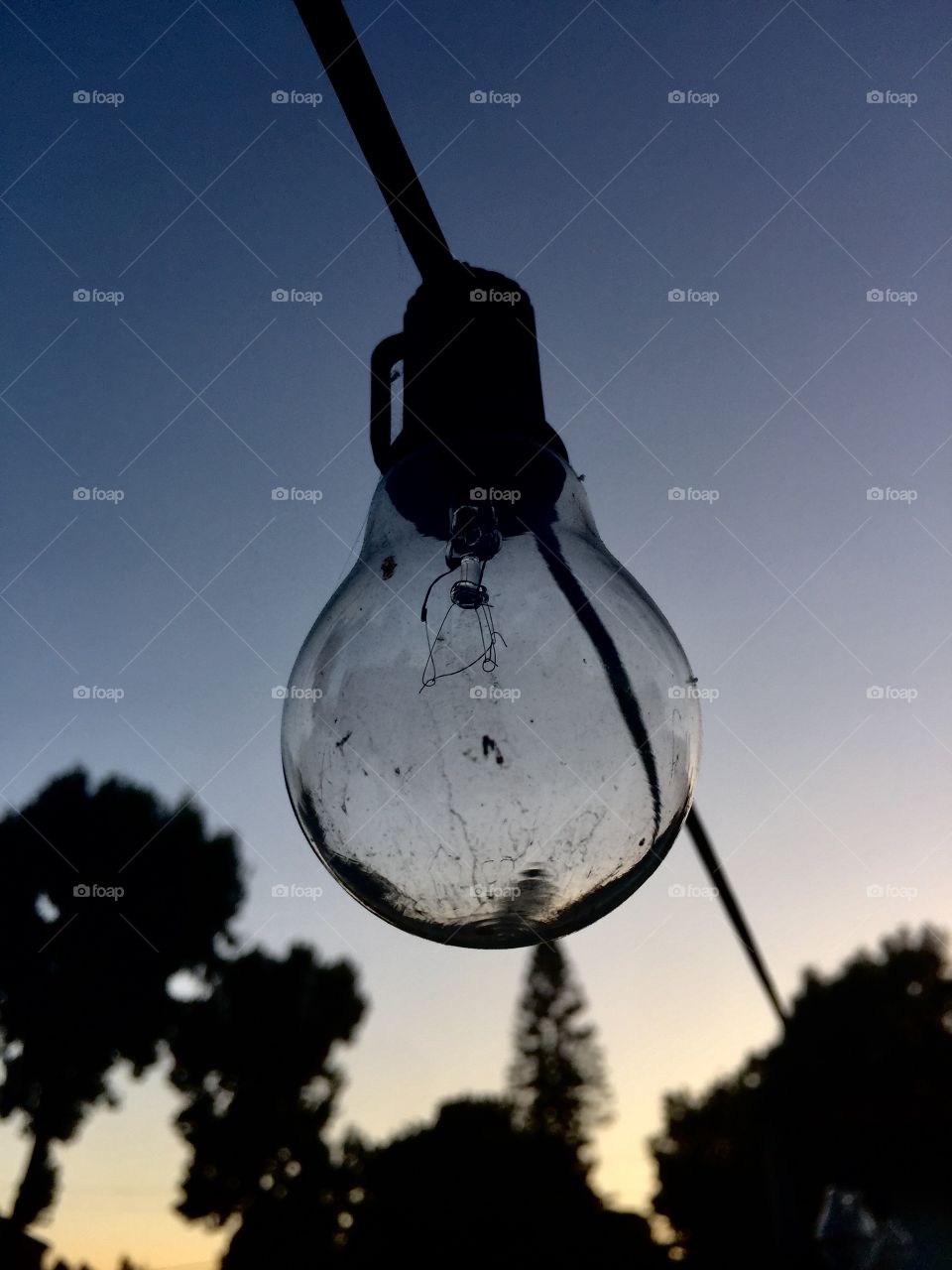 Inspiration strikes in unlikely places, as a single light bulb contrasts against the painted dusk sky.