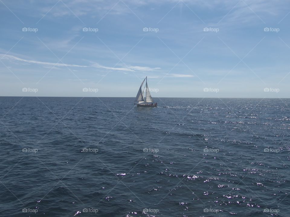 A sail boat on calm blue waters