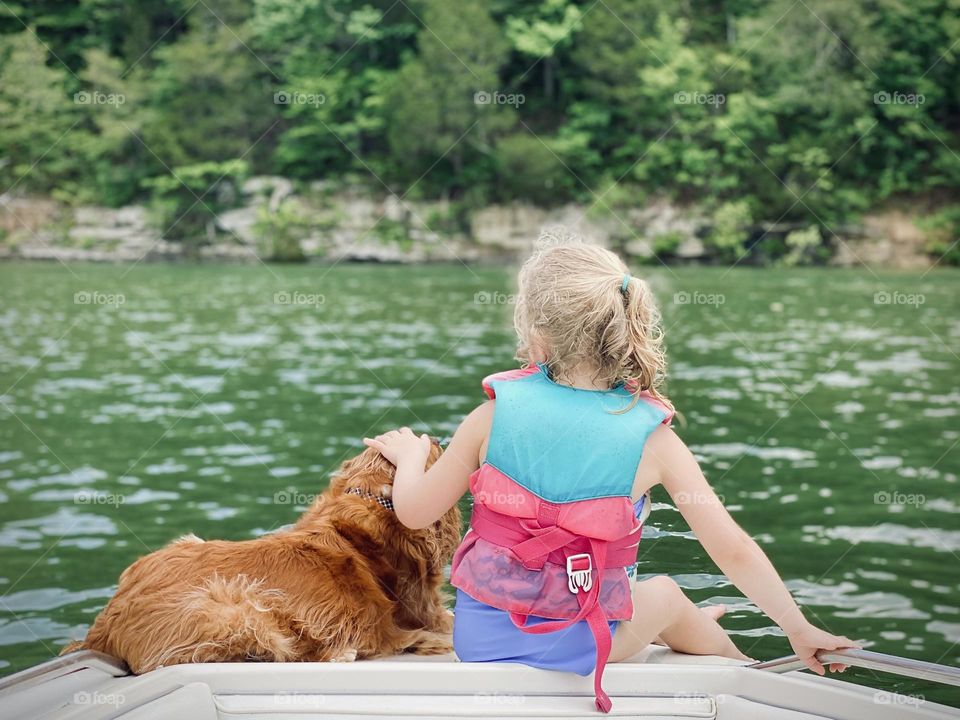 Just a kid and her pup enjoying spending some of their summertime on a boat 