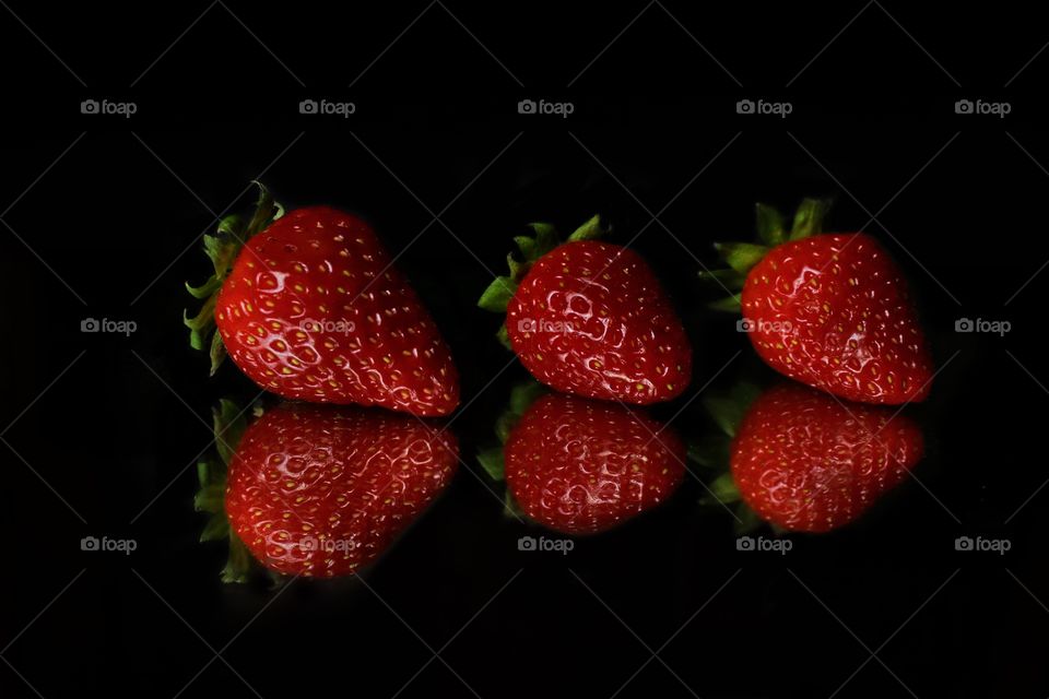 Three strawberries on black background 