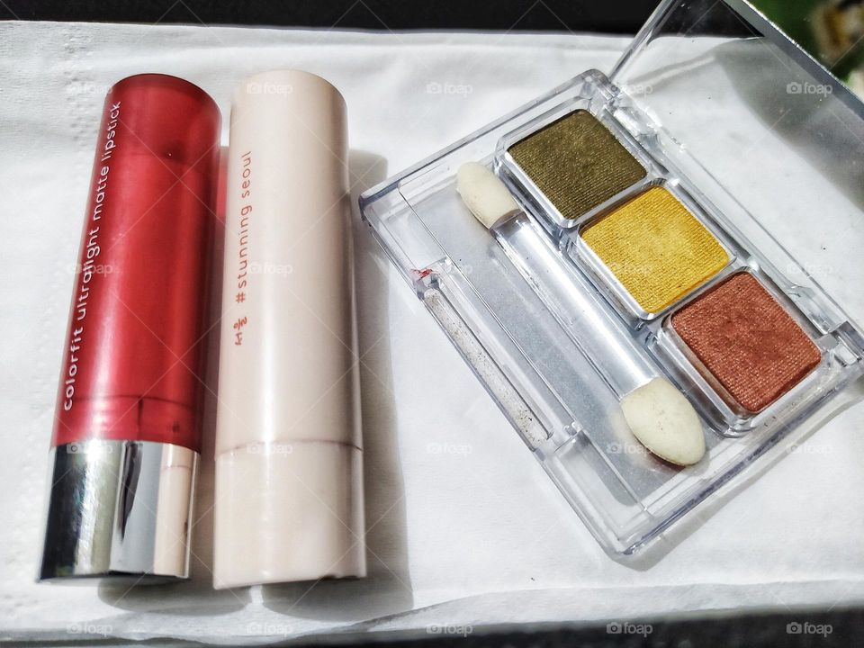 Top view, isolated on white background with some lipstick and eyeshadow kit