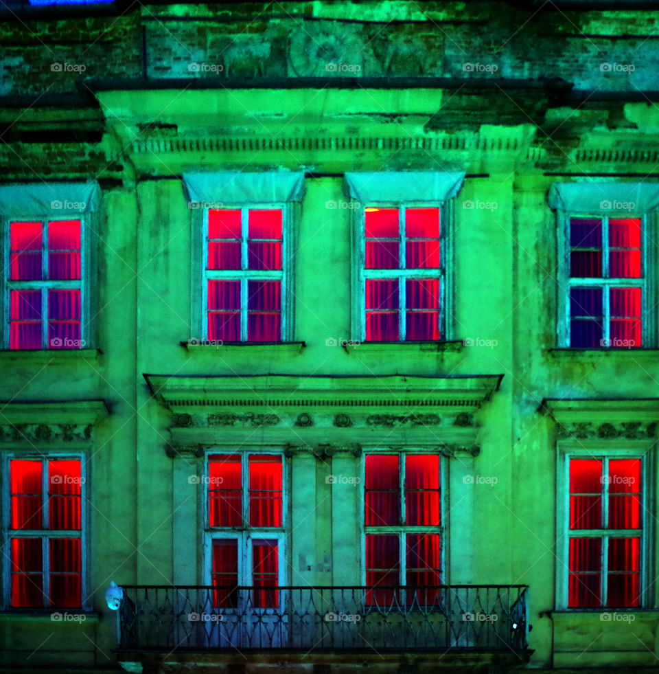 Red colored illuminated windows by night in Kraków, Poland.