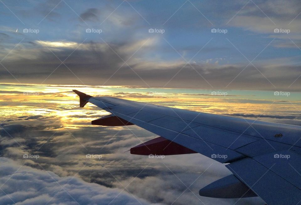 Wing of an airplane flying above the clouds