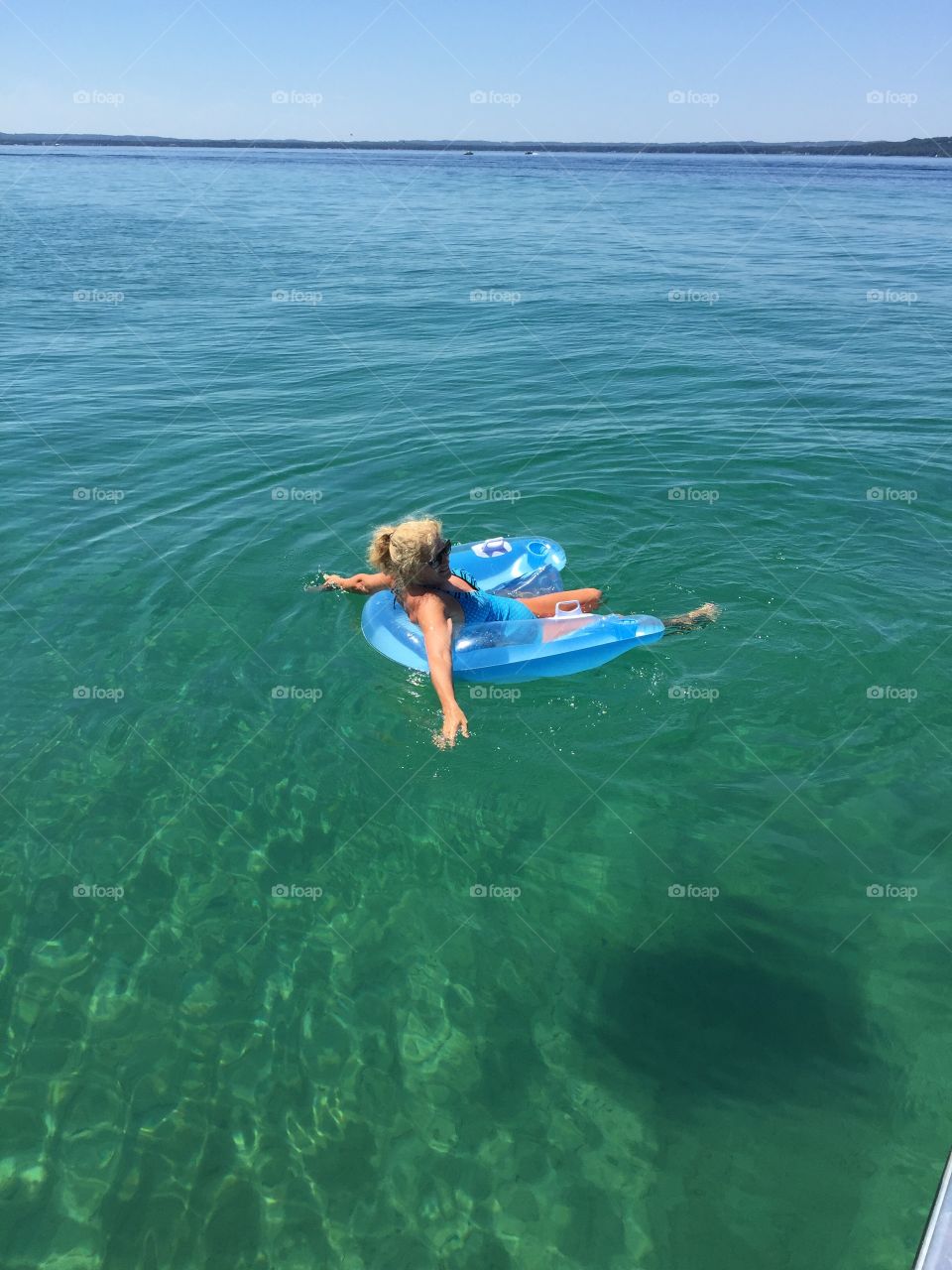 Woman sitting on inflatable chair in the sea