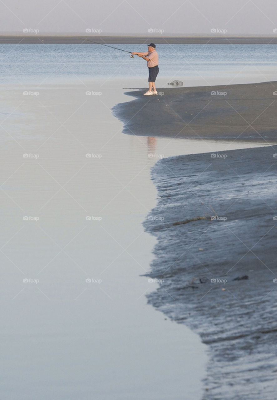 A lone fisherman casts on an estuary on the Sea of Cortez, Mexico.